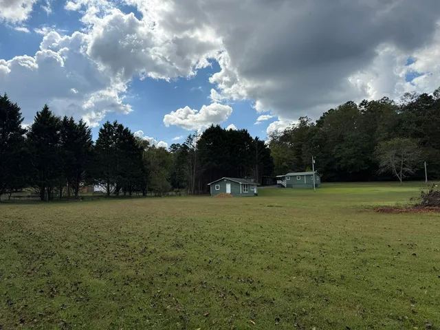 a view of a field with a house in the background