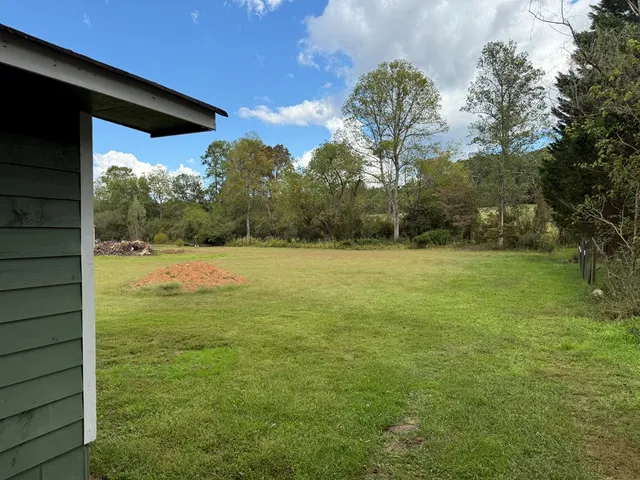 a view of a house with pool and a yard