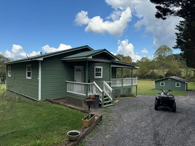 a view of an empty room with wooden floor and a fireplace