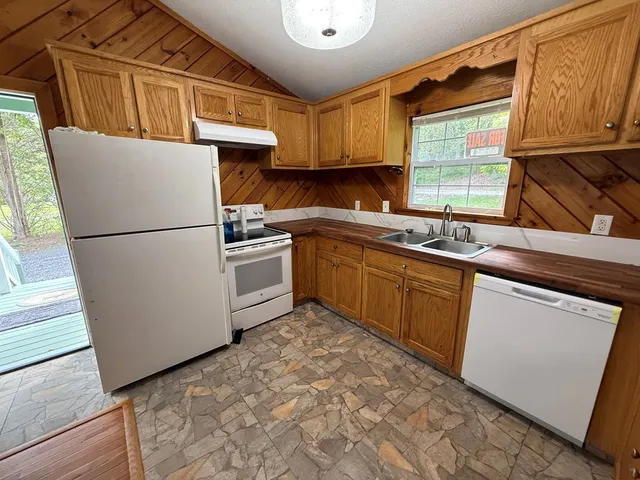 a kitchen with granite countertop a sink stainless steel appliances and cabinets