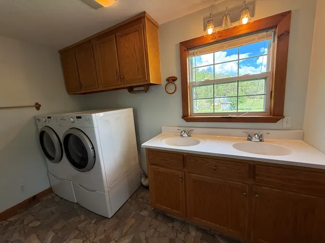 a utility room with sink dryer and washer