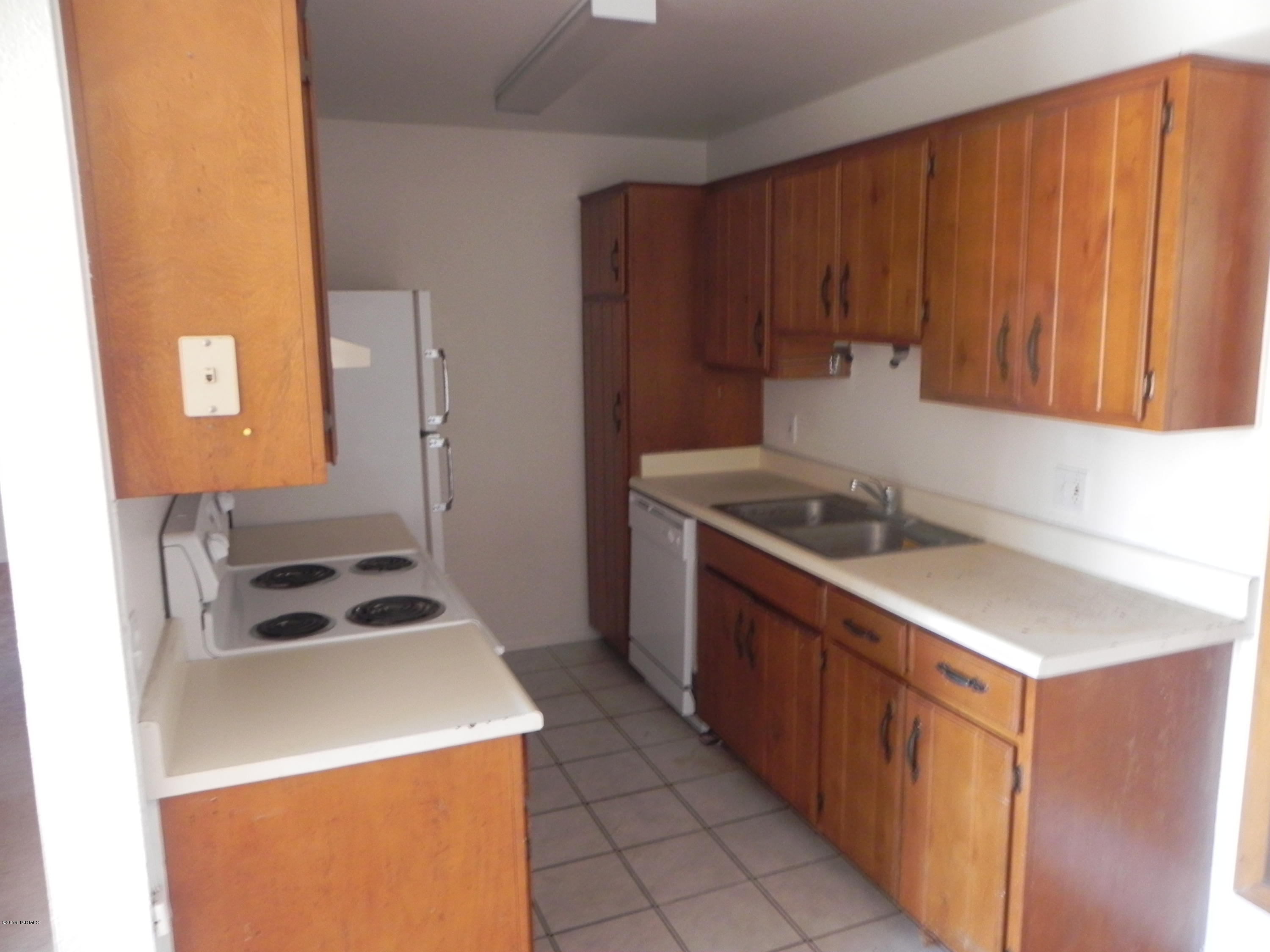 6625 East Golf Links Road, Unit 2 Tucson, AZ 85730 - Photo 3 of 14 a kitchen with a sink a stove and a refrigerator