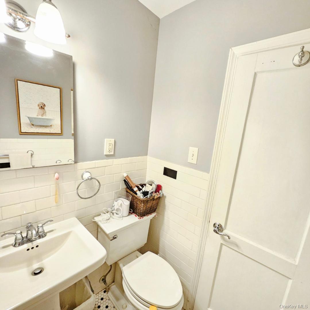 215-43 48th Avenue, Unit 3B Queens, NY 11364 - Photo 13 of 14 a bathroom with a sink mirror vanity and toilet