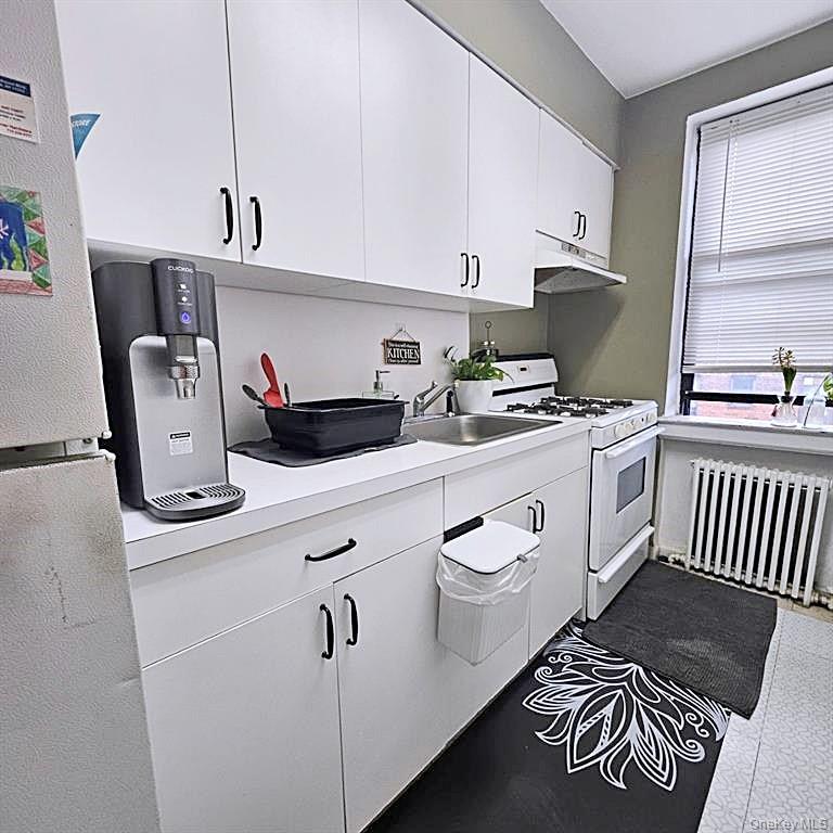 215-43 48th Avenue, Unit 3B Queens, NY 11364 - Photo 4 of 14 a kitchen with a stove a sink and a refrigerator