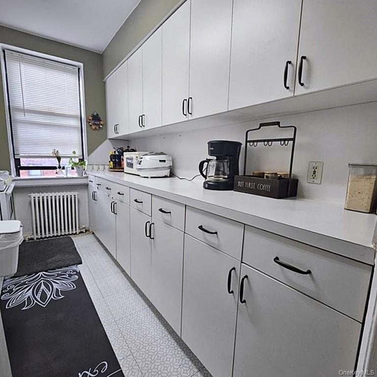 215-43 48th Avenue, Unit 3B Queens, NY 11364 - Photo 5 of 14 a kitchen with granite countertop cabinets a sink a window and stainless steel appliances