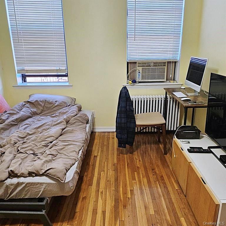 215-43 48th Avenue, Unit 3B Queens, NY 11364 - Photo 9 of 14 a bedroom with a bed and wooden floor