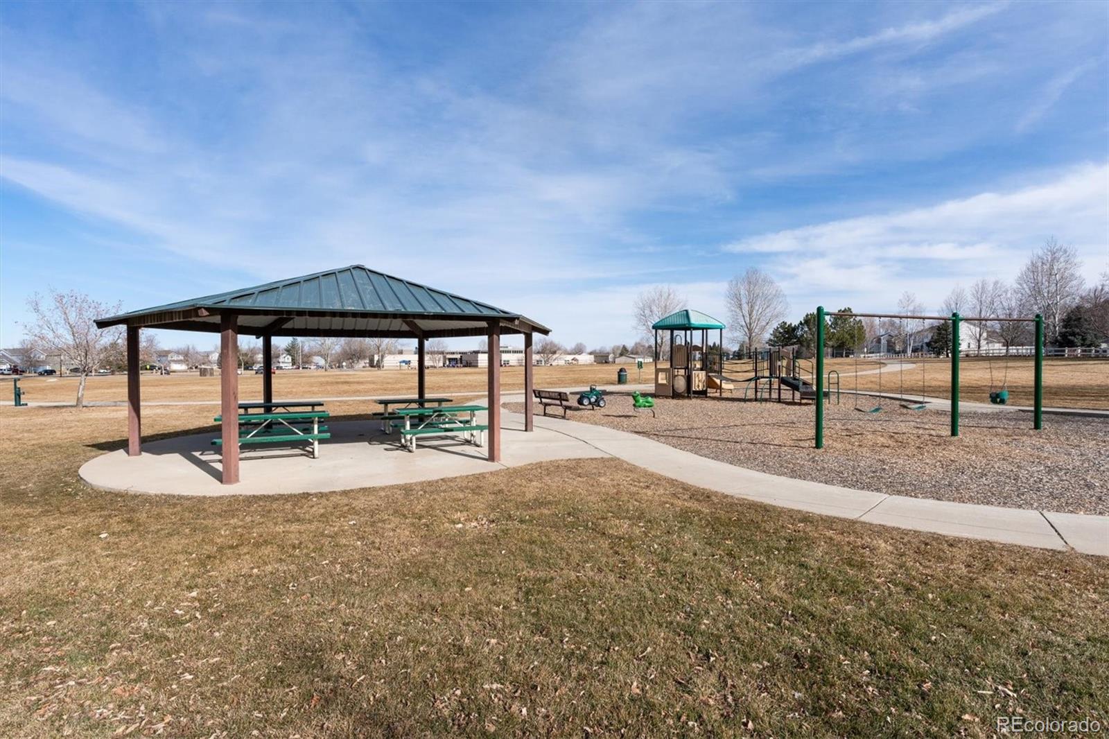 6485 Silverleaf Avenue Firestone, CO 80504 - Photo 25 of 29 a view of a swimming pool with a lawn chairs under an umbrella