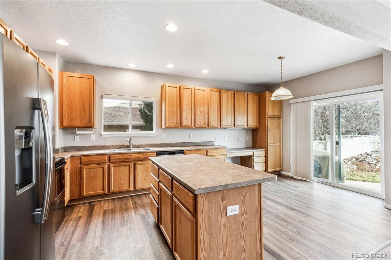 6485 Silverleaf Avenue Firestone, CO 80504 - Photo 7 of 29 a kitchen with granite countertop a sink a counter top space stainless steel appliances and a large window