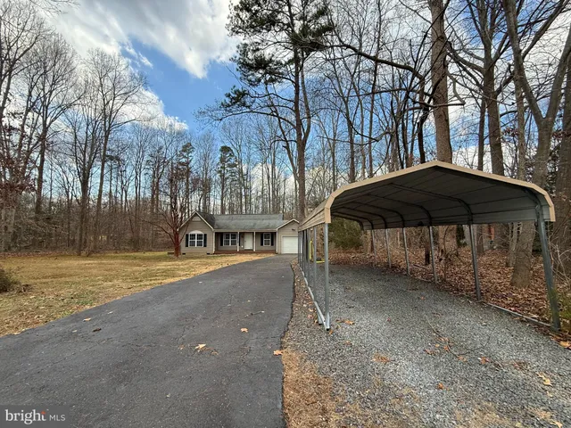 a view of a house with backyard and trees