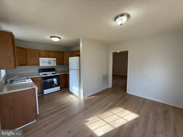 a kitchen with granite countertop a refrigerator and a stove top oven