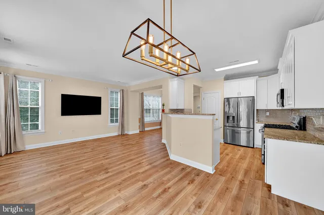 a view of a kitchen with microwave and wooden floor