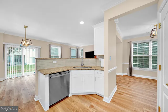 a kitchen with a sink stove and wooden floor