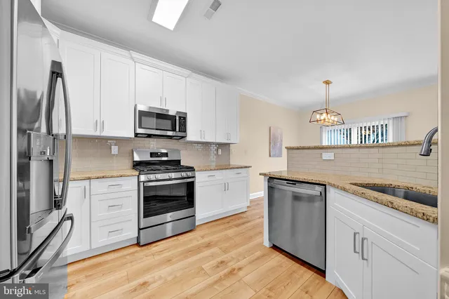 a kitchen with stainless steel appliances granite countertop a stove and a sink