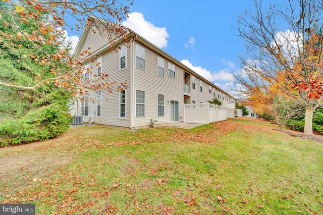 a view of a white house with a large yard and large trees
