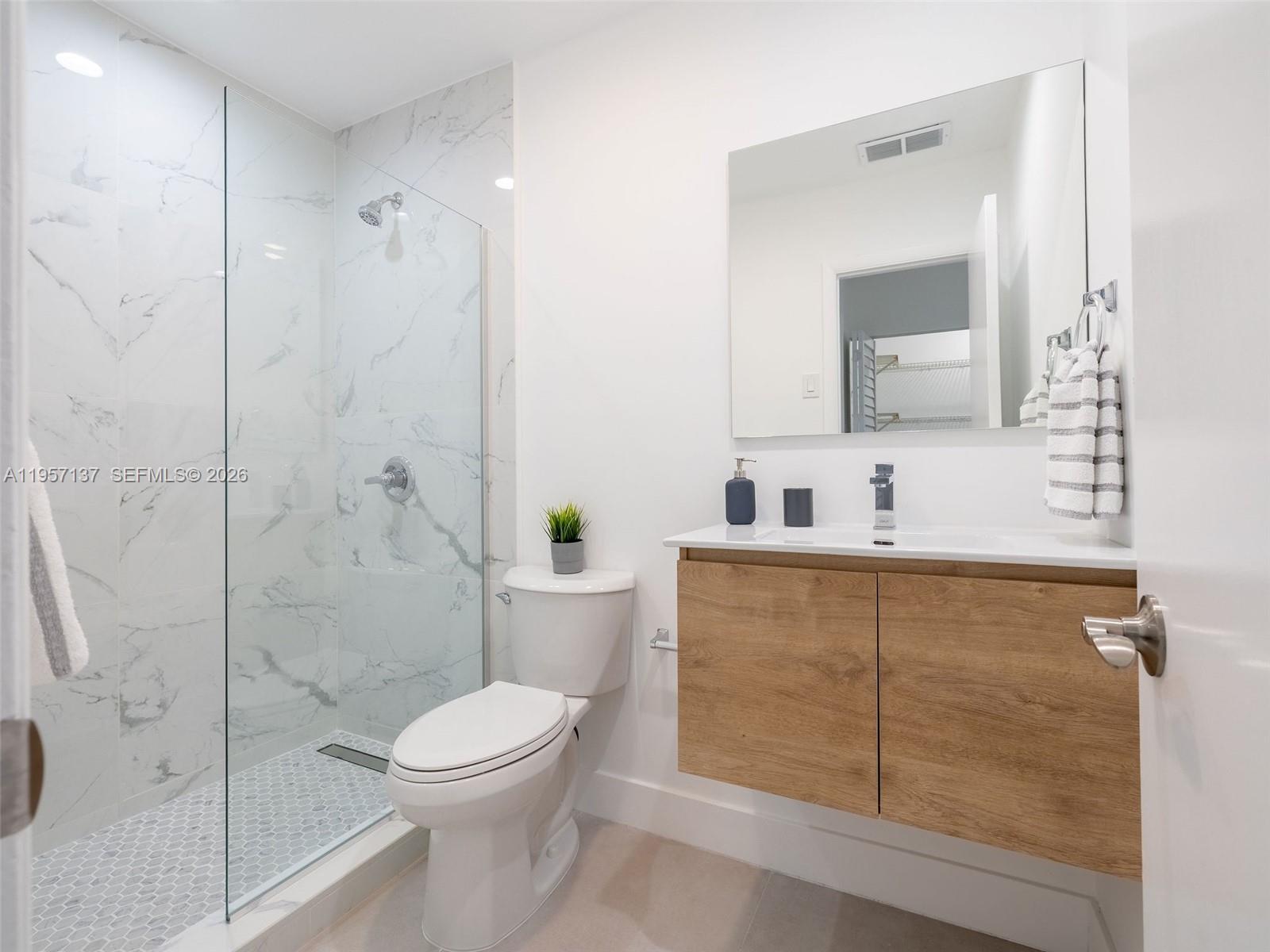 10988 Lake Front Place Boca Raton, FL 33498 - Photo 21 of 85 a bathroom with a sink a toilet and shower