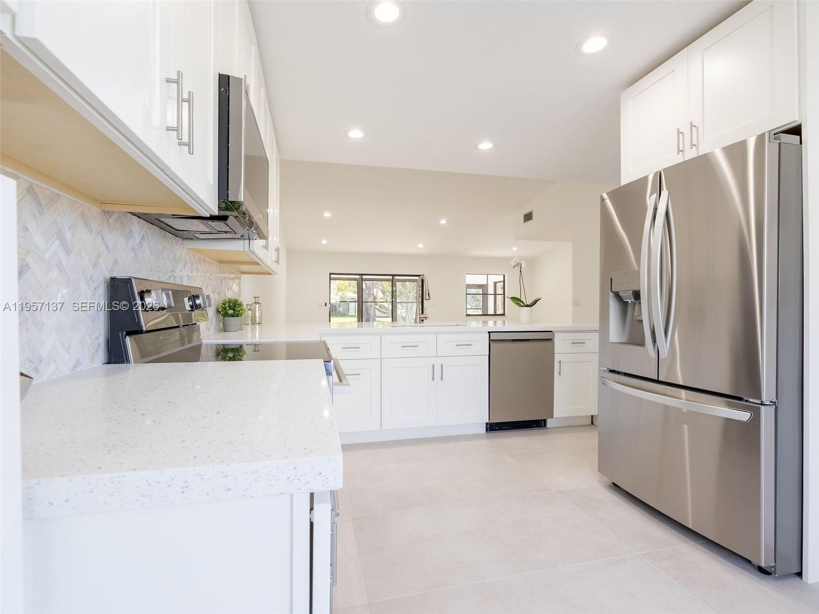 10988 Lake Front Place Boca Raton, FL 33498 - Photo 34 of 85 a kitchen with stainless steel appliances a refrigerator sink and white cabinets