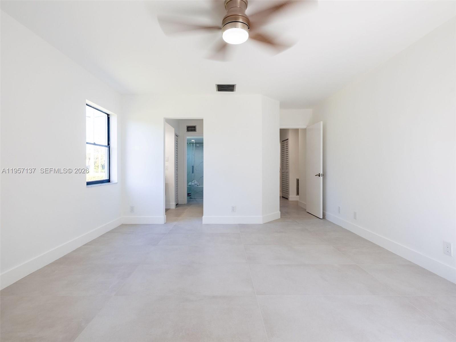 10988 Lake Front Place Boca Raton, FL 33498 - Photo 37 of 85 an empty room with a window and a ceiling fan