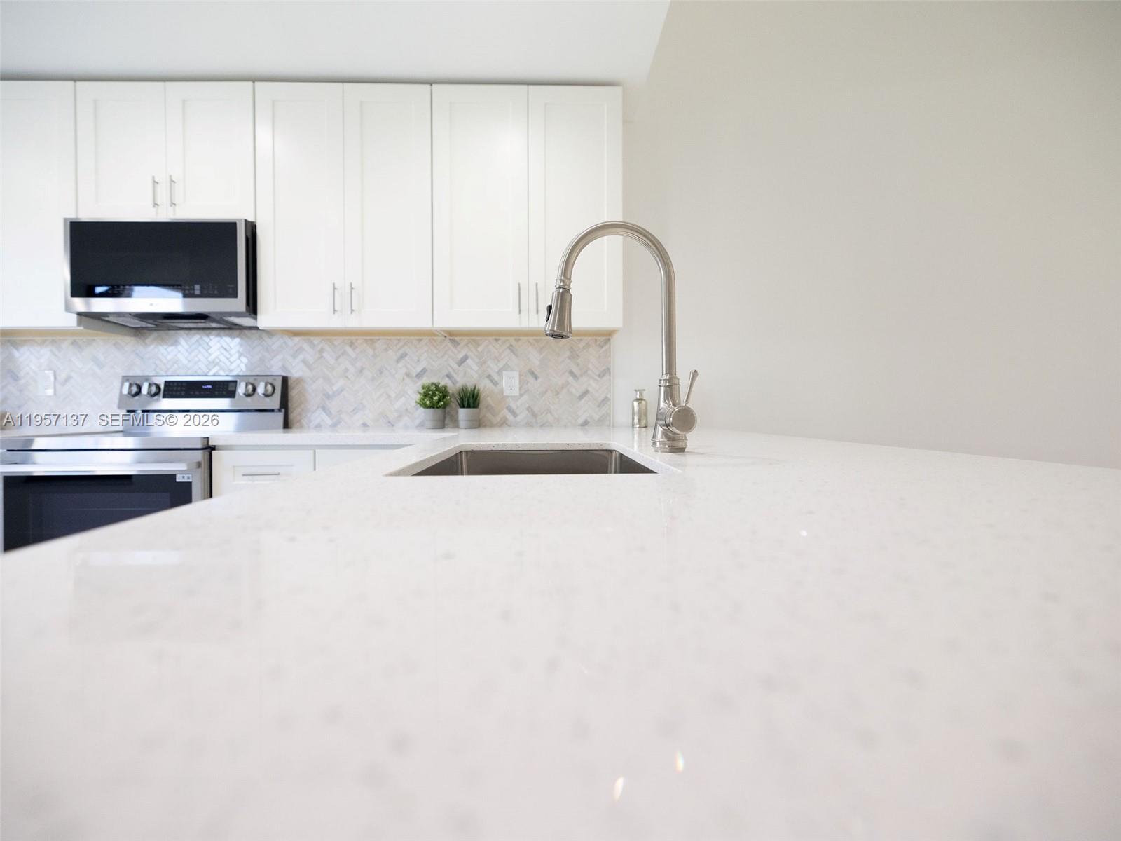 10988 Lake Front Place Boca Raton, FL 33498 - Photo 47 of 85 a close view of a sink and a microwave in a kitchen