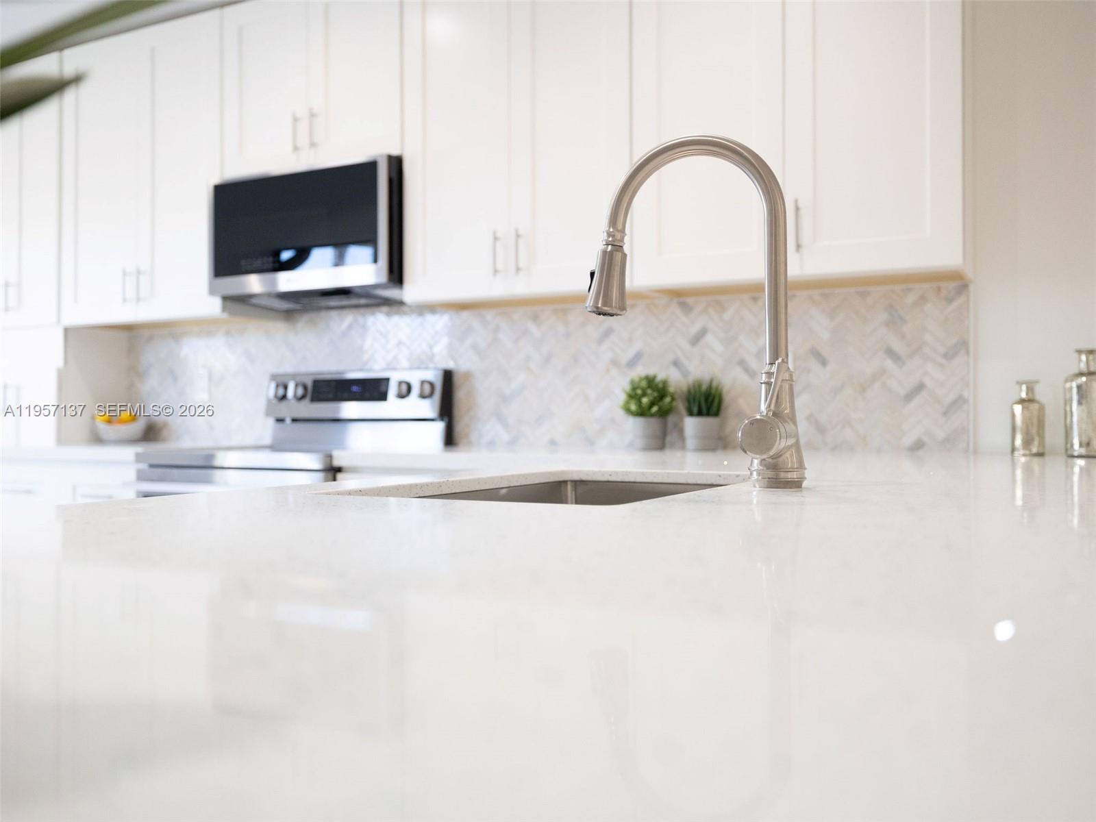 10988 Lake Front Place Boca Raton, FL 33498 - Photo 48 of 85 a kitchen with sink a microwave and cabinets
