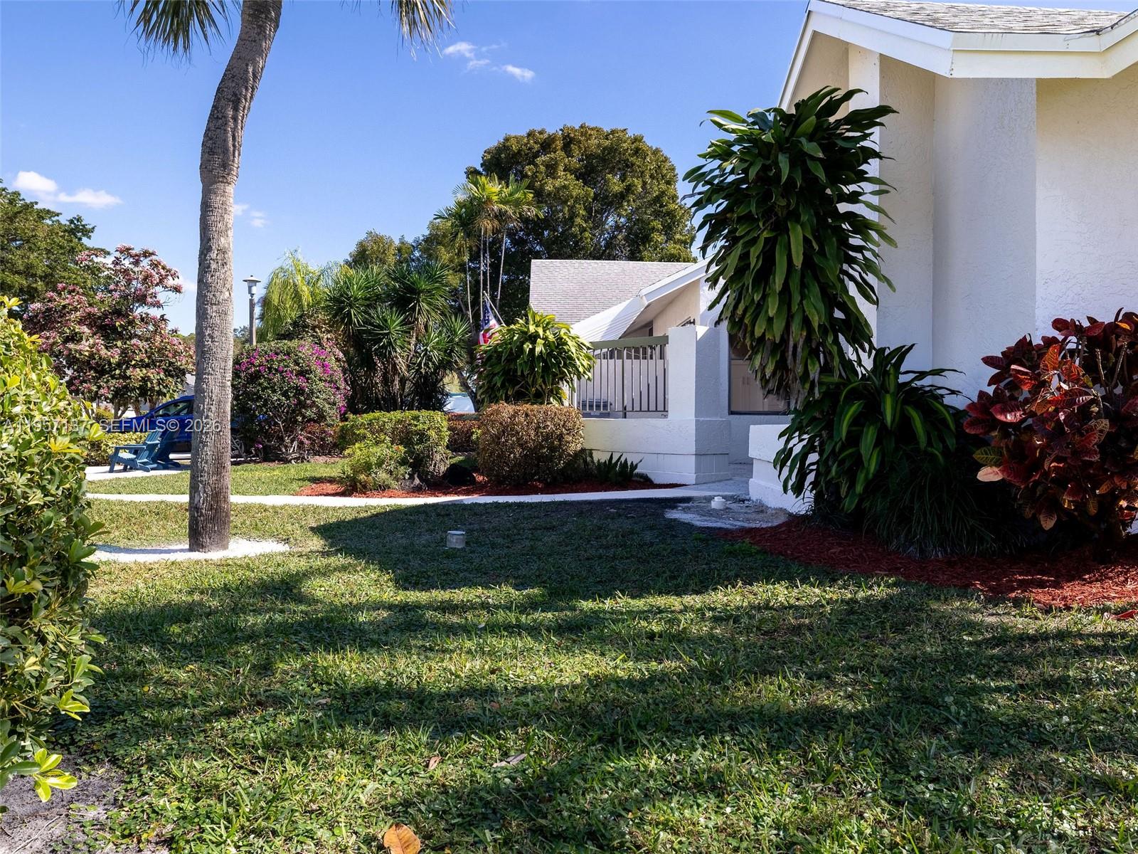 10988 Lake Front Place Boca Raton, FL 33498 - Photo 62 of 85 a view of a house with a yard and palm trees