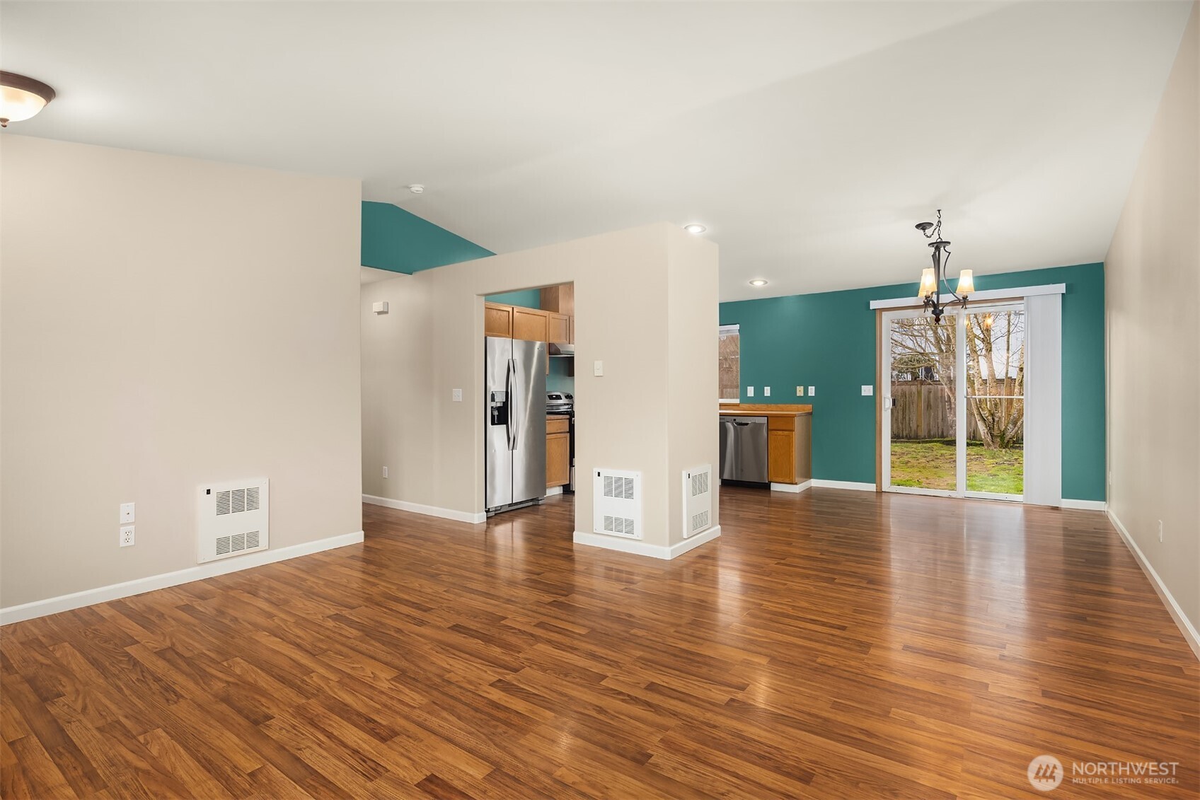 1019 Kessler Drive Sultan, WA 98294 - Photo 13 of 28 a view of an empty room with wooden floor and a kitchen