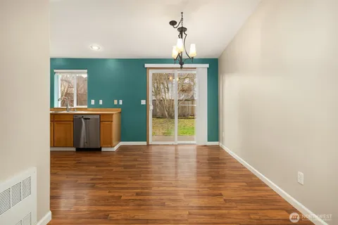 a view of a room with wooden floor chandeliers and kitchen