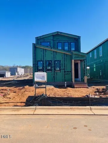 a front view of a house with porch and seating space