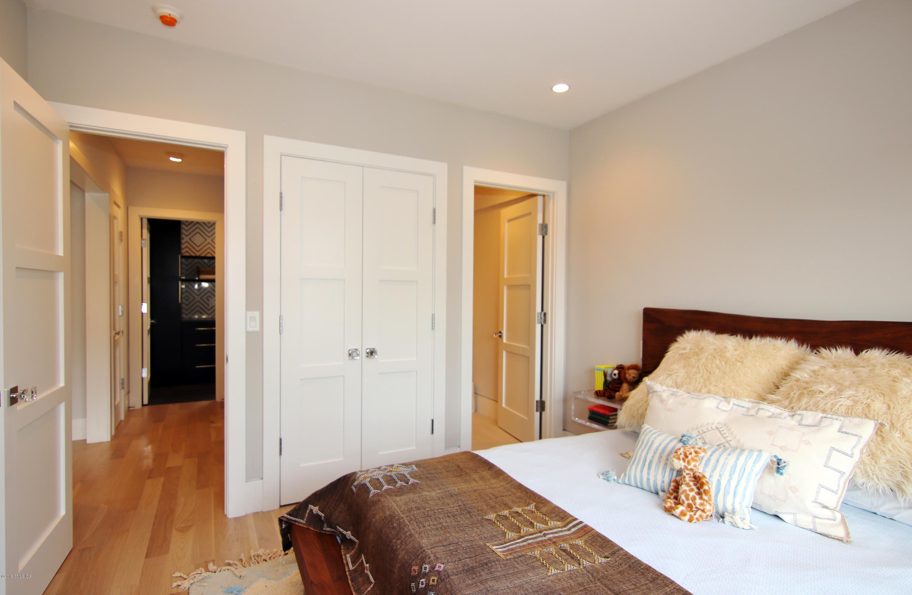 38 St Roch Avenue, Unit F Greenwich, CT 06830 - Photo 17 of 38 a bedroom with a bed and wooden floor