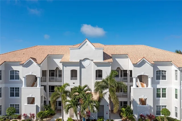 a view of a white house with a big yard and potted plants
