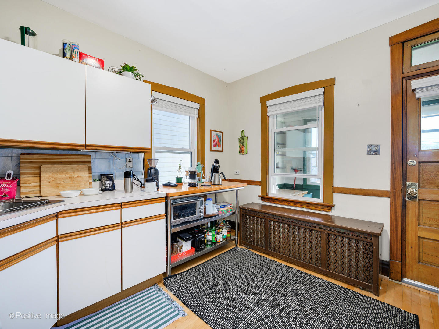 3016 South Throop Street Chicago, IL 60608 - Photo 16 of 32 a kitchen that has a lot of cabinets and wooden floor