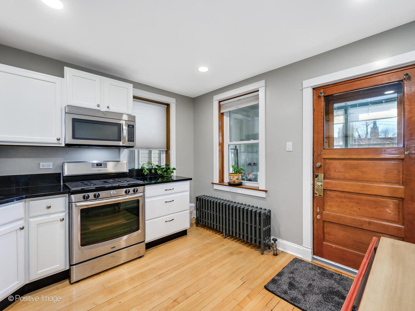 3016 South Throop Street Chicago, IL 60608 - Photo 7 of 32 a kitchen with stainless steel appliances granite countertop a stove a sink and a microwave