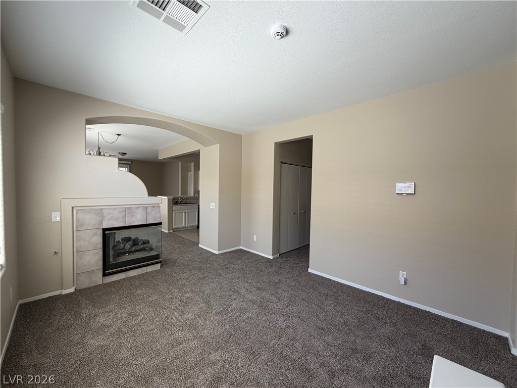 10975 Pumpkin Ridge Avenue Las Vegas, NV 89135 - Photo 4 of 13 A well-maintained interior offers comfortable carpeted flooring and a built-in fireplace feature.