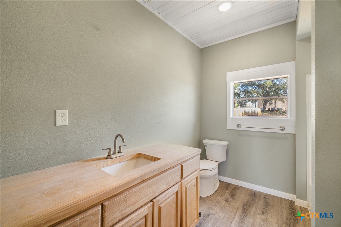 2205 Meyersville Road Meyersville, TX 77974 - Photo 19 of 22 a bathroom with a granite countertop sink mirror vanity and toilet