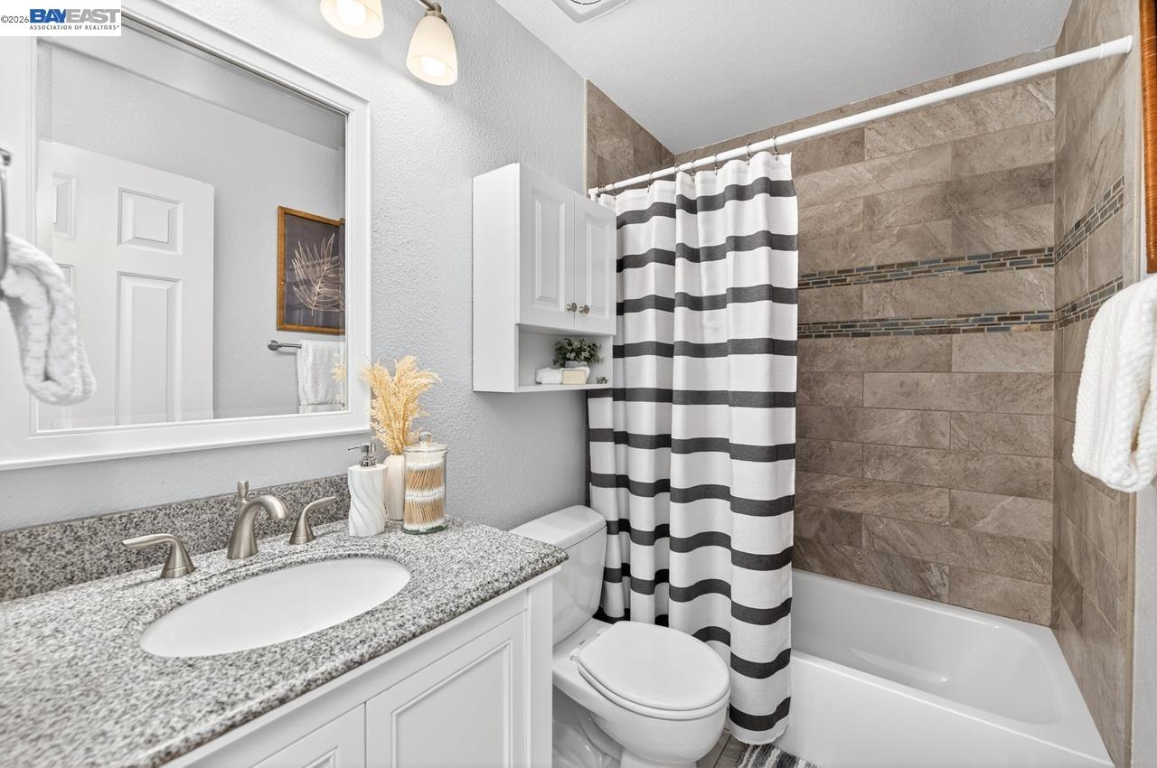 308 Mulqueeney Street Livermore, CA 94550 - Photo 21 of 51 a bathroom with a granite countertop sink toilet mirror and shower