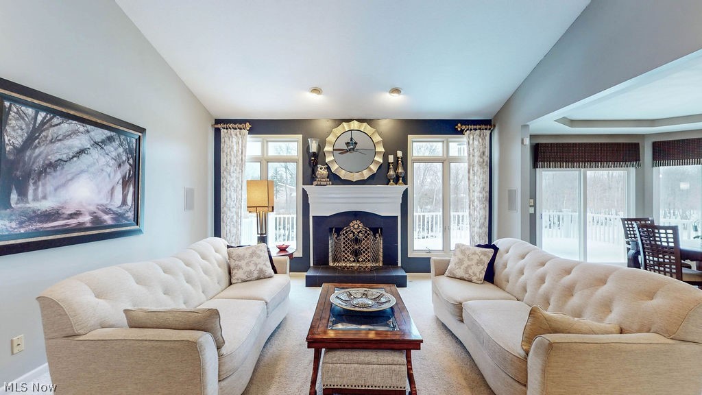 36845 Aberdeen Lane Solon, OH 44139 - Photo 6 of 24 Carpeted living room with lofted ceiling and a fireplace with raised hearth