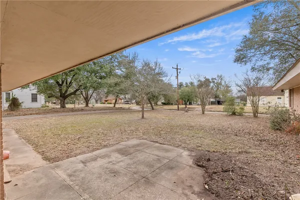 a front view of a house with a yard and large tree