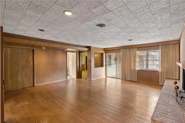 an empty room with wooden floor and fireplace