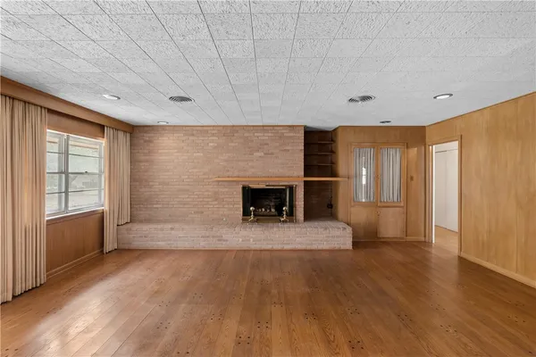 a view of an empty room with a fireplace and a window