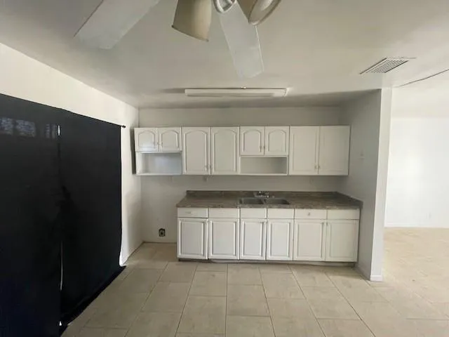 a kitchen with granite countertop a refrigerator and a sink