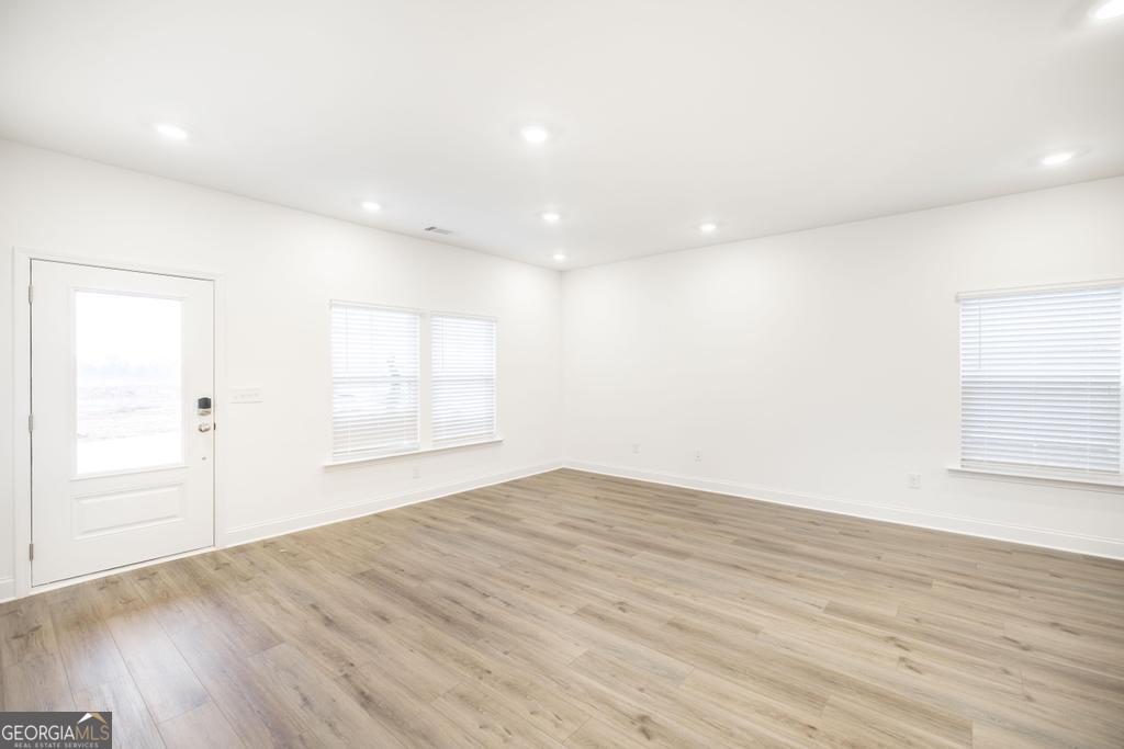108 Palmetto Avenue Perry, GA 31069 - Photo 6 of 30 an empty room with wooden floor and windows