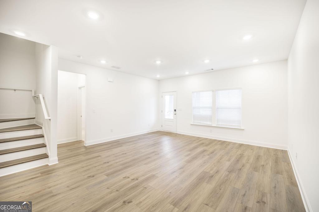 108 Palmetto Avenue Perry, GA 31069 - Photo 7 of 30 a view of an empty room with wooden floor and a window