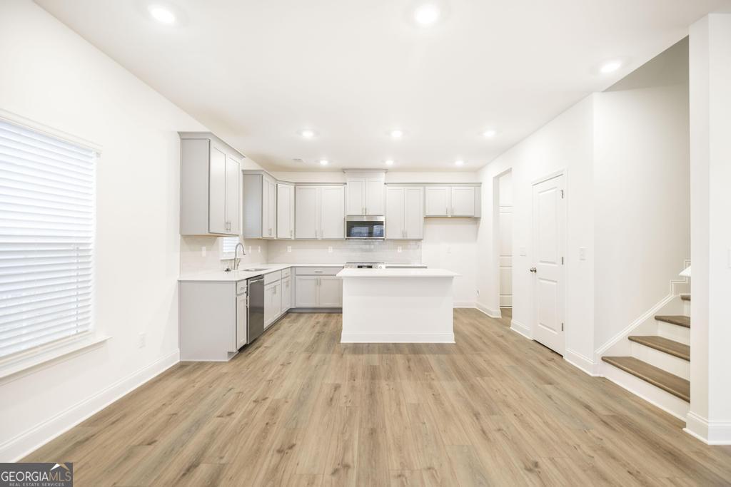 108 Palmetto Avenue Perry, GA 31069 - Photo 8 of 30 a large kitchen with a lot of counter space and wooden floor