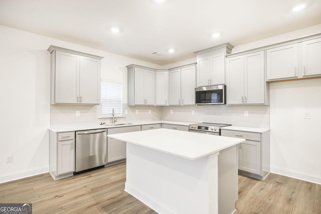 108 Palmetto Avenue Perry, GA 31069 - Photo 9 of 30 a kitchen with stainless steel appliances granite countertop a stove a sink and white cabinets