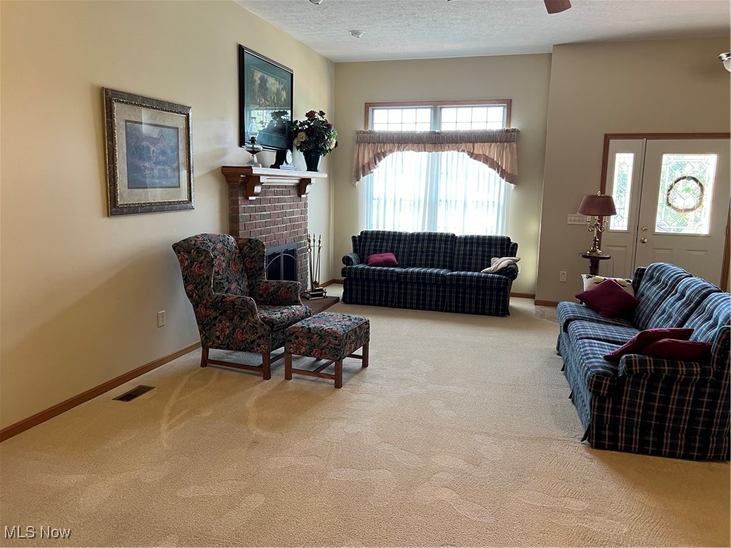 2195 Scenic View Road Southwest New Philadelphia, OH 44663 - Photo 5 of 17 Carpeted living room featuring a textured ceiling and a brick fireplace