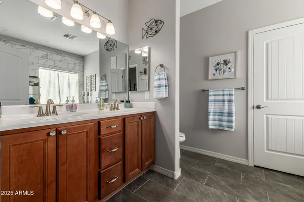 a spacious bathroom with a double vanity sink a large mirror and a shower