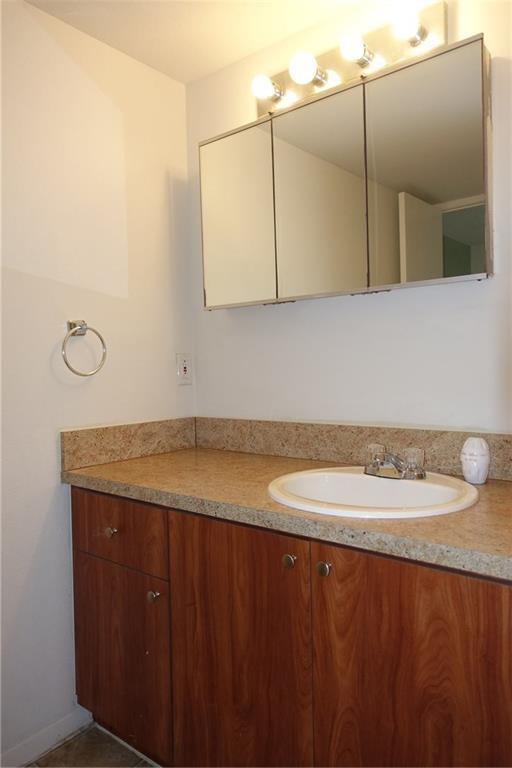 4088 North Pine Island Road, Unit 409 Sunrise, FL 33351 - Photo 12 of 18 a bathroom with a granite countertop sink and a mirror