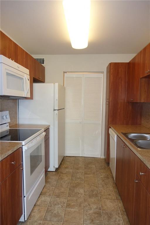 4088 North Pine Island Road, Unit 409 Sunrise, FL 33351 - Photo 2 of 18 a kitchen with a stove top oven and refrigerator