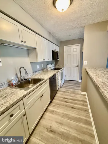 a kitchen with granite countertop a sink and cabinets