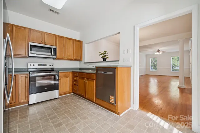 a kitchen with stainless steel appliances granite countertop a stove a sink and a refrigerator