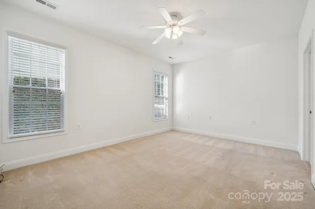 an empty room with a window and a ceiling fan